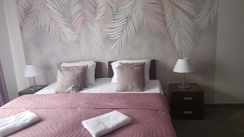 オストルダにあるWilla Port Apartament 203のベッドルーム1室(ピンクの毛布と枕が備わる大型ベッド1台付)