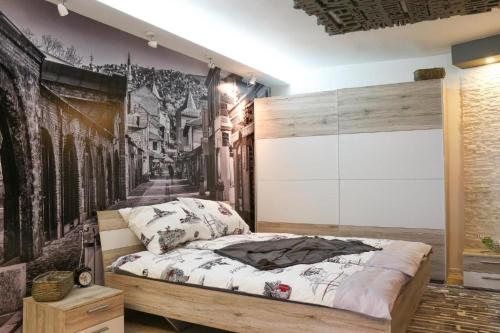 - une chambre avec un lit orné d'une fresque murale dans l'établissement Old Corner apartments Sarajevo, à Sarajevo