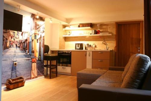 Il comprend un salon avec un canapé et une cuisine. dans l'établissement Old Corner apartments Sarajevo, à Sarajevo