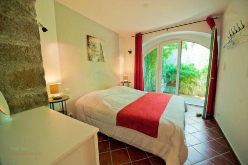 a bedroom with a bed and a large window at Les chemins de la Cité Chambre ou appartement in Carcassonne