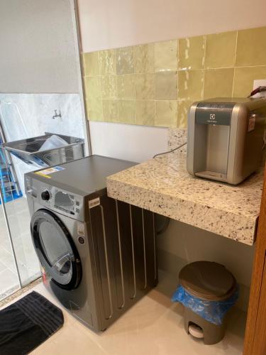 uma cozinha com uma máquina de lavar roupa e um micro-ondas em Apartamento Concierge Sensacional em Marabá