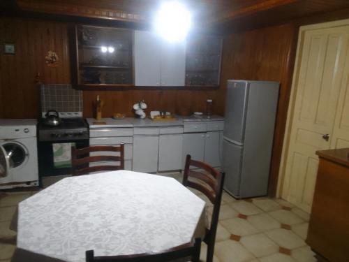 uma cozinha com uma mesa branca e um frigorífico em Nino Apartement Zugdidi em Zugdidi