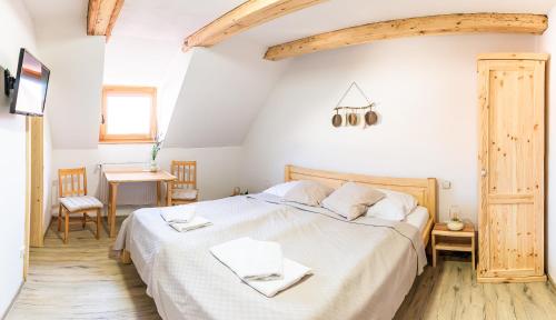 a bedroom with a large bed with white sheets at Althanský hostinec in Znojmo