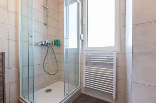 uma casa de banho com um chuveiro e uma porta de vidro em Tiffy studio w private parking em Zadar