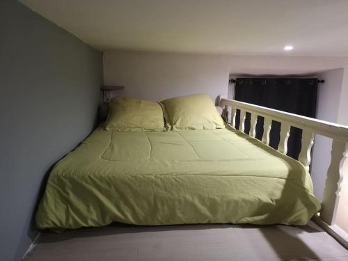 ein Bett mit grüner Bettwäsche und Kissen in einem Schlafzimmer in der Unterkunft F1 37m² hyper centre face au marché in Ajaccio