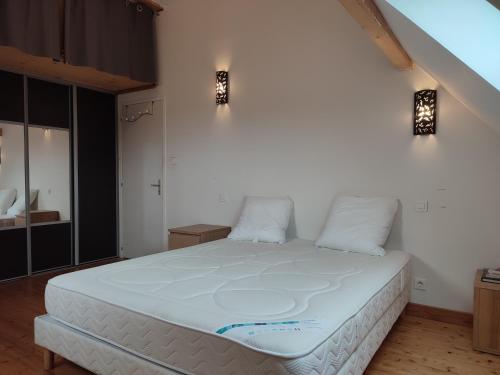 une chambre avec un grand lit blanc avec deux oreillers dans l'établissement Le Clos du Château, à Rully