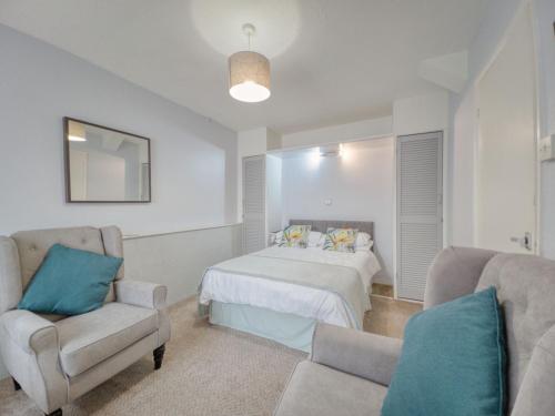 een slaapkamer met een bed, een bank en een stoel bij Apartment 8 - Large Studio Sea Front-Ground floor -Free Parking in Paignton