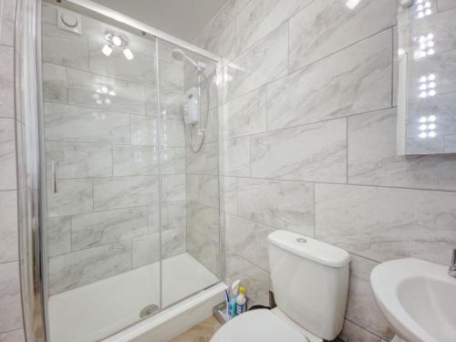 een badkamer met een douche, een toilet en een wastafel bij Apartment 8 - Large Studio Sea Front-Ground floor -Free Parking in Paignton