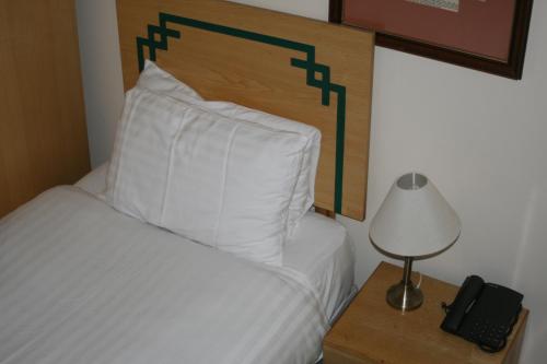 a bedroom with a bed and a lamp and a phone at Hanover Hotel & McCartney's Bar in Liverpool