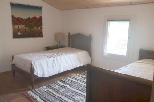 une chambre avec deux lits et une fenêtre dans l'établissement Gîte de l'arbre perché à Langel, à Armissan