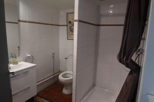 une salle de bain blanche avec des toilettes et un lavabo dans l'établissement Gîte de l'arbre perché à Langel, à Armissan