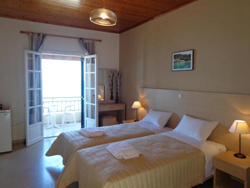 sypialnia z 2 łóżkami i balkonem w obiekcie Akrogiali Rooms w mieście Boukari