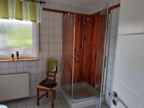 uma casa de banho com um chuveiro, uma banheira e uma cadeira. em Gemütlich wohnen in Welling em Welling