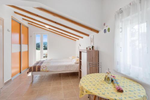 a bedroom with a bed and a table at Apartments Čikat Mali Lošinj in Mali Lošinj