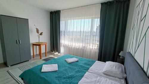 a bedroom with a bed with two towels on it at Noclegi na Piaskach in Krynica Morska