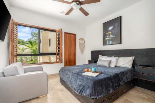 a bedroom with a bed and a couch and a window at Private Tulum Villa in Exclusive Secured Community in Tulum