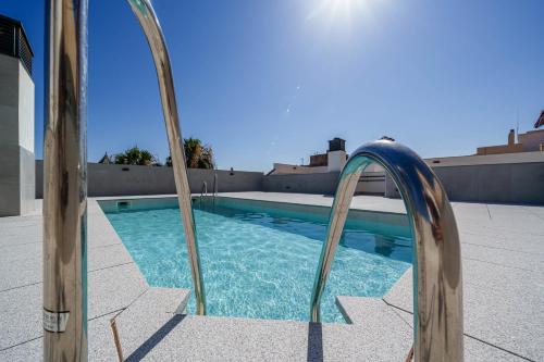 una piscina con dos barras de metal junto a una piscina en City Centre Pool & Parking, en Málaga