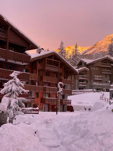 a ski lodge in the snow with snow covered trees at Ma tanière aux 7 Laux in Les Adrets