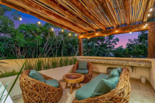 a patio with chairs and a couch and a table at Private Tulum Villa in Exclusive Secured Community in Tulum