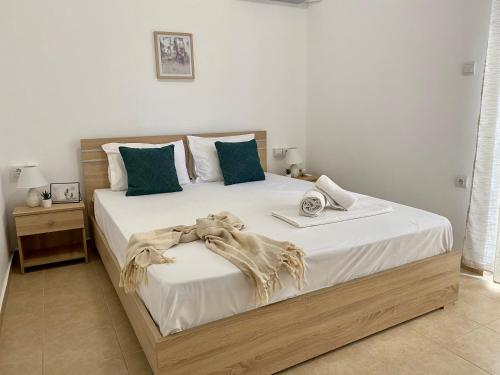 a bedroom with a large bed with white sheets and blue pillows at Elgreco Apartment, near the sea, in Kos town "14" in Kos
