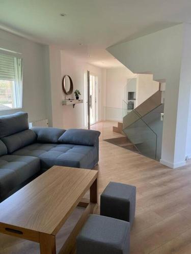 uma sala de estar com um sofá azul e uma mesa em Chalet en Aldán em Cangas de Morrazo