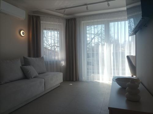 a living room with a couch and large windows at Sileo Apart No.85 in Ustka