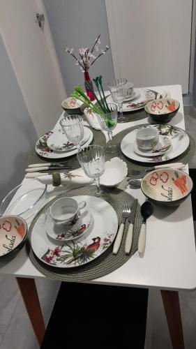 a white table with plates and utensils on it at Loft 37 Centro histórico in São Paulo