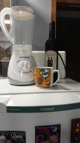a blender and a bottle of wine on top of a refrigerator at Loft 37 Centro histórico in Sao Paulo