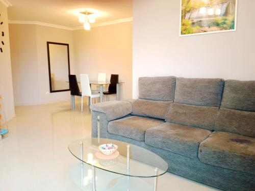 - un salon avec un canapé et une table en verre dans l'établissement Apartamento San Francisco, à Viveiro
