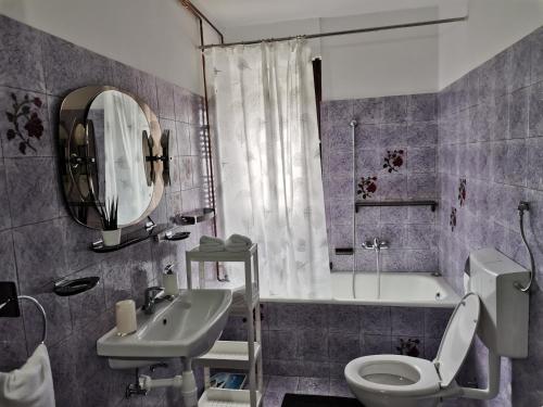 a bathroom with a sink and a toilet and a tub at Apartma David in Most na Soči