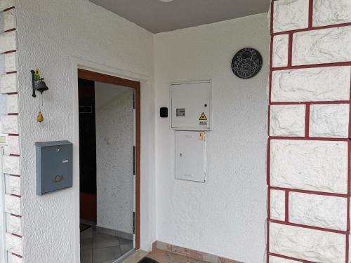 an empty room with a door and a clock on the wall at Apartma David in Most na Soči