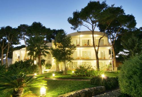 a large white building with lights in the yard at Melia Cala d'Or Boutique Hotel in Cala d´Or