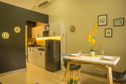 a kitchen with a table and a refrigerator at FLAWLESS LODGE EN IMBANACO, Cali-Colombia in Cali
