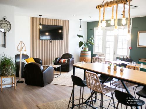 een woonkamer met een tafel en stoelen bij The Originals City Hôtel Bordeaux Porte du Bassin in Gradignan