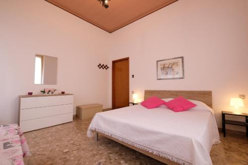 Un dormitorio con una cama blanca con almohadas rosas. en Orchidea PT - Pineto Vacanza, en Pineto