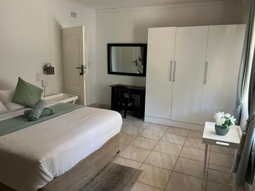 a bedroom with a bed and a table with a mirror at Angelmalatji guesthouse in Graskop
