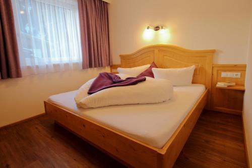 a bedroom with a bed with white sheets and a window at Alexandra's Apartment in Neustift im Stubaital