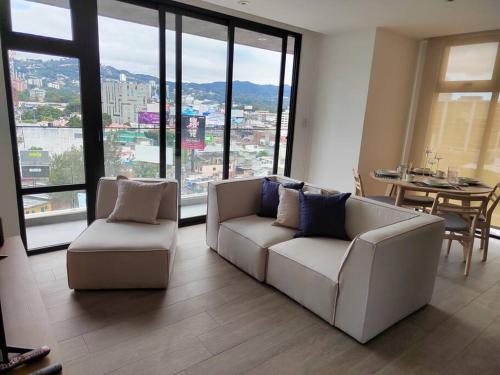 a living room with two white couches and a table at Hermoso apartamento nuevo en zona 10! in Guatemala