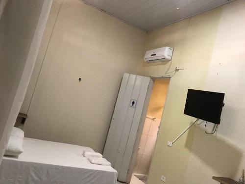 Zimmer mit 2 Betten, einer Tür und einem TV in der Unterkunft Pousada Villa Rica in Carolina