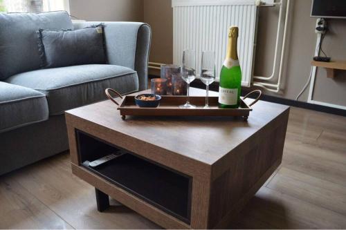 a bottle of champagne on a coffee table in a living room at ‘t Bosrandje in Odoorn