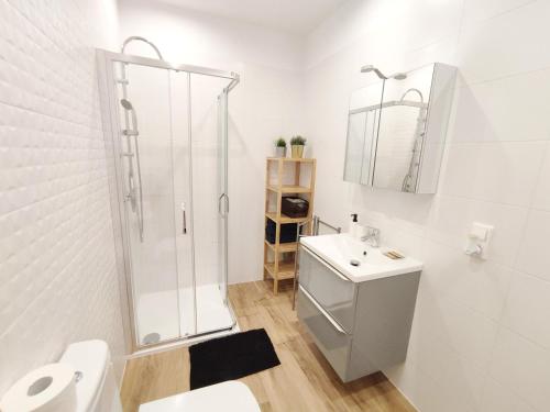 baño blanco con ducha y lavamanos en Apartament "Stay with Us" en Toruń
