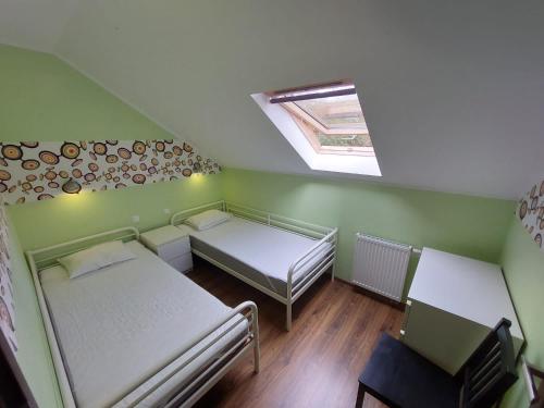 a small room with two beds and a skylight at Apartament Południowy in Debina