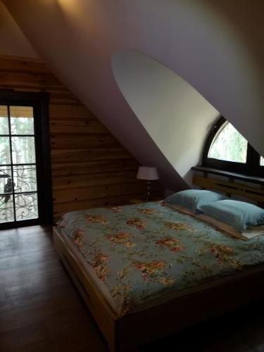a bedroom with a bed and a window at Antalieptės sodyba in Baibiai