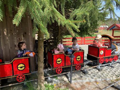 a group of children riding on a toy train at Ferienhaus Spielburg in Altötting