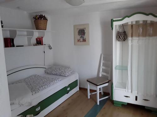 a small bedroom with a bed and a chair at Ferienhaus in Zempin mit Garten in Zempin