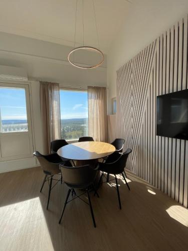 ein Esszimmer mit einem Tisch und Stühlen sowie einem TV in der Unterkunft Näköalahuoneisto AARNI & NAAVA in Ukkohalla