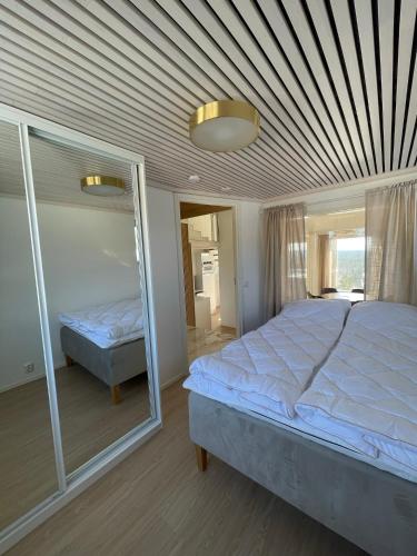 een slaapkamer met een groot bed en een spiegel bij Näköalahuoneisto AARNI & NAAVA in Ukkohalla