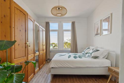 a bedroom with a bed and a window at Cozy Antwerp - Sunny Zurenborg in Antwerp