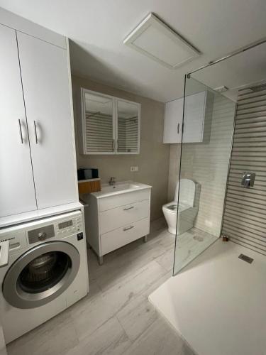 a bathroom with a washing machine and a toilet at IGiDELUX in Era de Soler