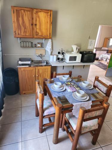a kitchen with a wooden dining table and chairs at Tjokkerland in Cradock